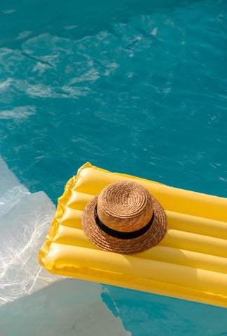 Woven hat on a yellow inflatable raft in a pool